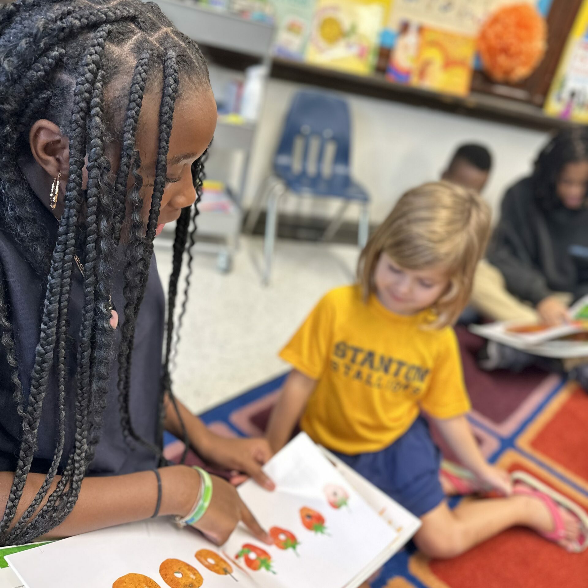 Older and younger students at Edwin M. Stanton School read together during a classroom literacy activity.
